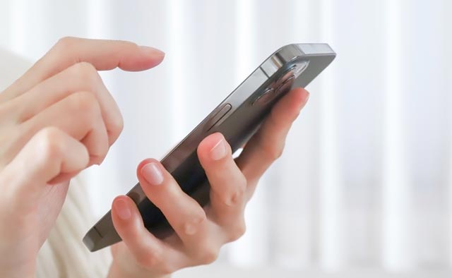 家族葬の目黒区葬儀社に電話でお問合せしようとしている人の手元。